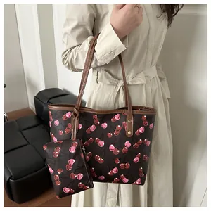 Détail d'un grand sac cabas à imprimé cerise avec sa petite pochette assortie