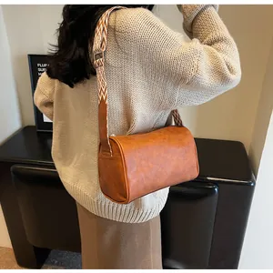 Stylish brown pillow bag with wide geometric pattern strap for women daily wear.