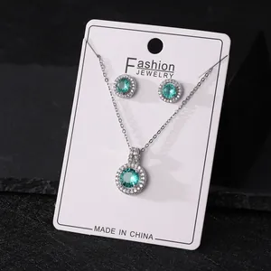 Detail of round green zircon jewelry set featuring silver necklace and earrings.