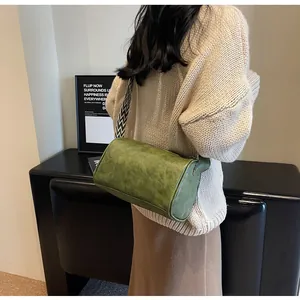 Detail view of a green pillow bag with a patterned wide strap worn by a model