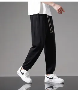 Detail view of men's lightweight black cotton joggers featuring a stylish drawstring waist