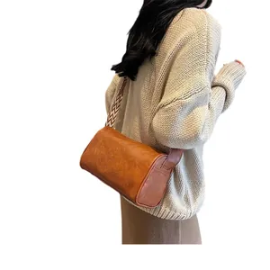 Stylish brown pillow crossbody bag with a wide patterned strap for daily fashion.