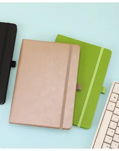 Detail view of A5 notebooks with elastic bands in bronze and green colors.