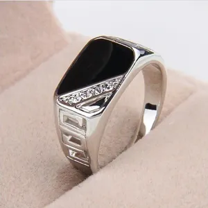 Macro detail shot of a silver men's ring with black enamel inlay and small stones