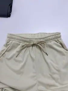 Close-up detail of beige casual pants waistband with adjustable drawstring