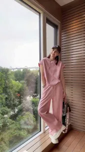 Elegante completo lounge rosa due pezzi con felpa a maniche corte e pantaloni larghi.