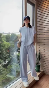 Woman wearing a loose light blue short-sleeve hoodie and matching wide-leg pants set
