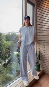 Donna che indossa un set di felpa con cappuccio azzurra e pantaloni larghi coordinati