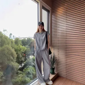 Set sportivo grigio da donna a due pezzi con felpa a maniche corte e pantaloni larghi.