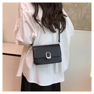Back view of a model wearing a stylish black minimalist leather crossbody square bag
