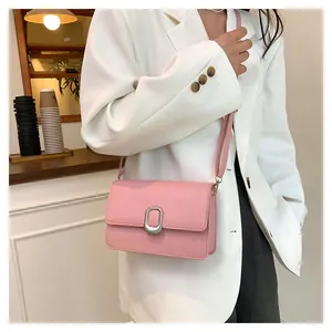 Detailed view of the elegant pink crossbody bag with silver buckle worn by a model