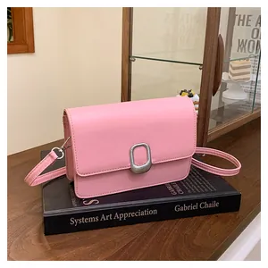 Detailed view of fashionable pink square crossbody bag featuring a silver oval metal buckle