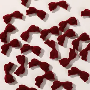 Close-up of wine red velvet bow charms for DIY hair accessories and phone case crafts