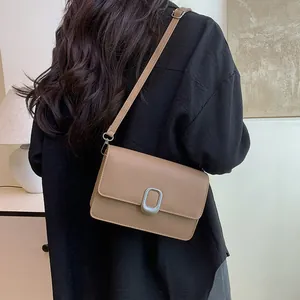 Minimalist khaki crossbody square bag with elegant silver oval buckle worn by model