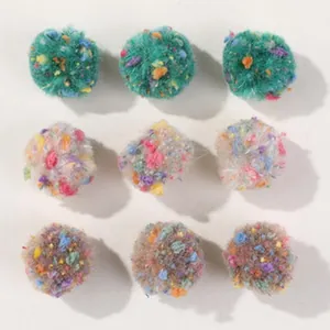 Close-up macro view of nine colorful speckled plush pompoms for DIY hair accessory crafts