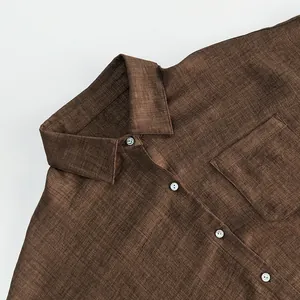 Macro detail of a brown short-sleeved button-down shirt with linen texture and pocket