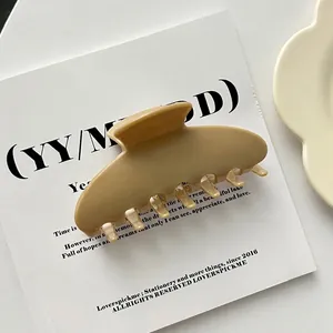 Detailed macro view of a large tan acrylic hair claw clip with a smooth finish