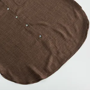Close-up shot of a brown linen-textured button-down shirt showing fabric detail and hem
