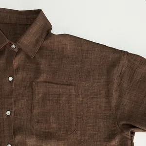 Detail macro view of brown linen shirt texture with chest pocket and white buttons