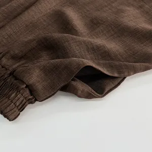 Close-up of brown linen-texture shorts with elastic waist and side pocket