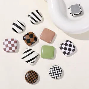 Detailed macro view of checkerboard and striped square buttons for DIY hair accessories