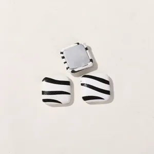 Detailed macro view of square black and white zebra pattern buttons for DIY hair accessories