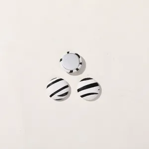 Close-up detail of round black and white zebra pattern buttons for DIY craft projects