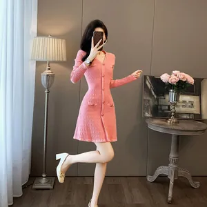 Robe courte en maille rose élégante avec col en V, boutons Chanel et coupe ajustée.