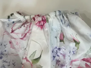 Close-up of vibrant pink floral print fabric with elasticated gathers on spring dress