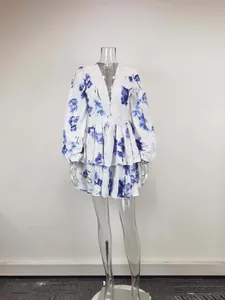 Close-up detail of a white floral mini dress with V-neck and puff sleeves on mannequin.