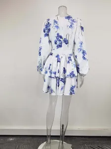 Detailed back view of a white mini tiered dress with blue floral pattern and lantern sleeves