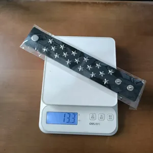 Punk rock leather bracelet with star rivets weighing 13.3g shown on a scale
