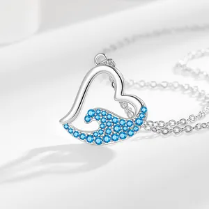 Silver heart necklace featuring blue rhinestone ocean wave design on white surface