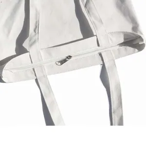 Minimalist white canvas tote bag with zipper closure and durable shoulder straps