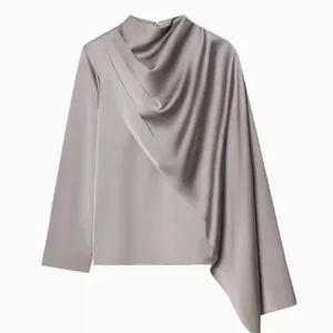 Détail élégant d'un haut en satin drapé avec un design de cape asymétrique chic