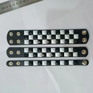 Punk black and white checkered pyramid rivet leather bracelets with a ruler for scale