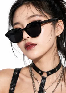 Close-up of a model wearing retro black square frame sunglasses with a gothic choker