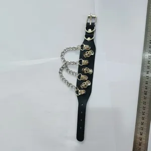 Detailed view of punk PU leather bracelet with silver skull charms and chains next to a ruler.