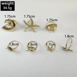 Vue détaillée d'un ensemble de 7 bagues dorées sur le thème marin avec perles et dimensions