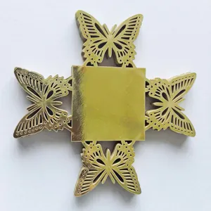 Détail du décor en carton papillon évidé doré pour boîtes à bonbons de mariage.