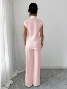 Back view of elegant pink short-sleeved shirt and straight trousers set for women