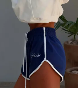 Close-up of blue athletic shorts with white trim and Roar embroidery detail