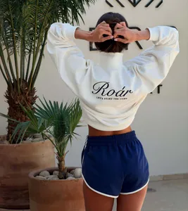 Back view of a white half-zip sweatshirt and navy athletic shorts set with 'Roar' print.
