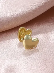 Close-up detail of elegant golden heart-shaped non-pierced ear clips on pink satin