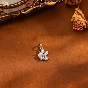 Macro view of a leaf branch pendant with micro-pave white zircons on brown texture