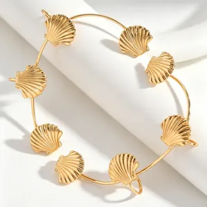 Vista dettagliata del cuff per orecchie dorato con vari ciondoli a forma di conchiglia