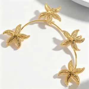 Primo piano di un ear cuff a forma di stella marina dorata con design marino
