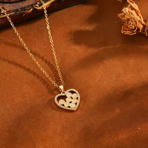 Gros plan d'un pendentif cœur doré avec perles pêche et oxydes de zirconium