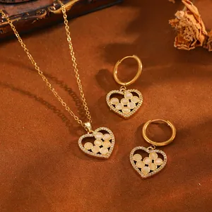 Vue détaillée d'un élégant ensemble collier et boucles d'oreilles cœur doré avec zircon