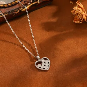 Détail rapproché du collier cœur en acier inoxydable orné de perles blanches et zircons